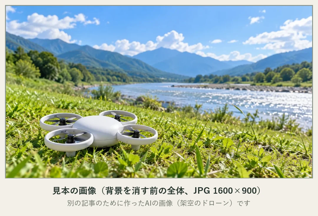 見本の画像。背景を消す前の全体で、河川敷の芝生の上に白いドローンが置かれ、奥に川と山並み、青空と雲が広がっている。別の記事のために作ったAIの画像